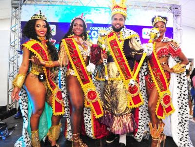 três mulheres e um homem com roupas de carnaval